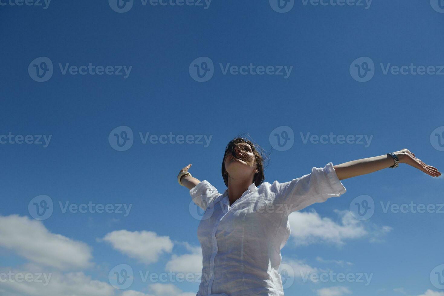 felice giovane donna con le braccia allargate al cielo foto