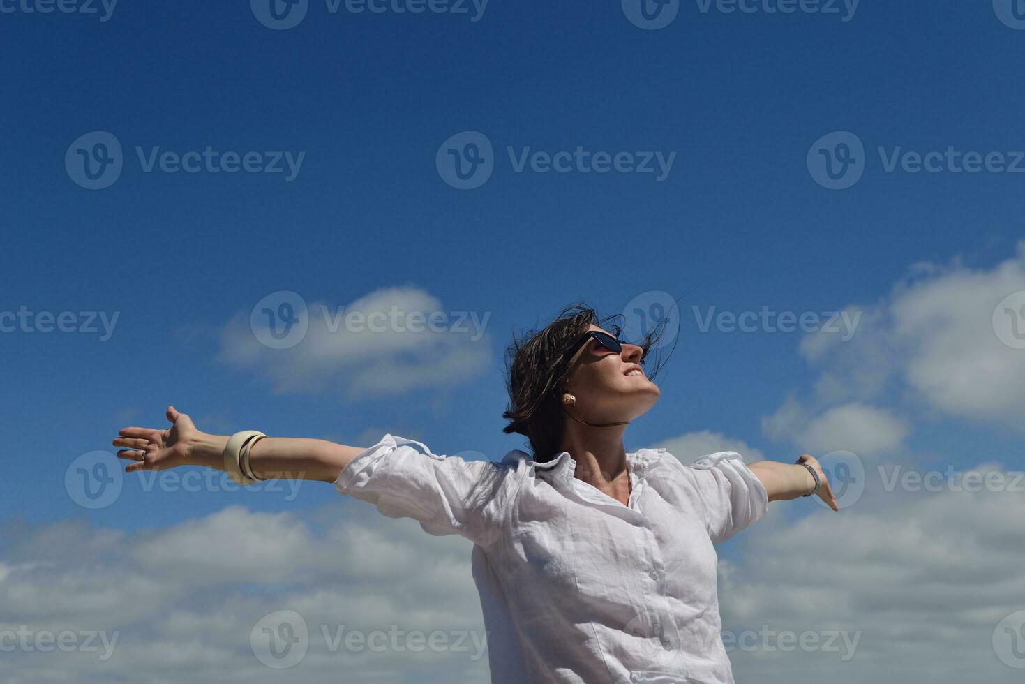 felice giovane donna con le braccia allargate al cielo foto