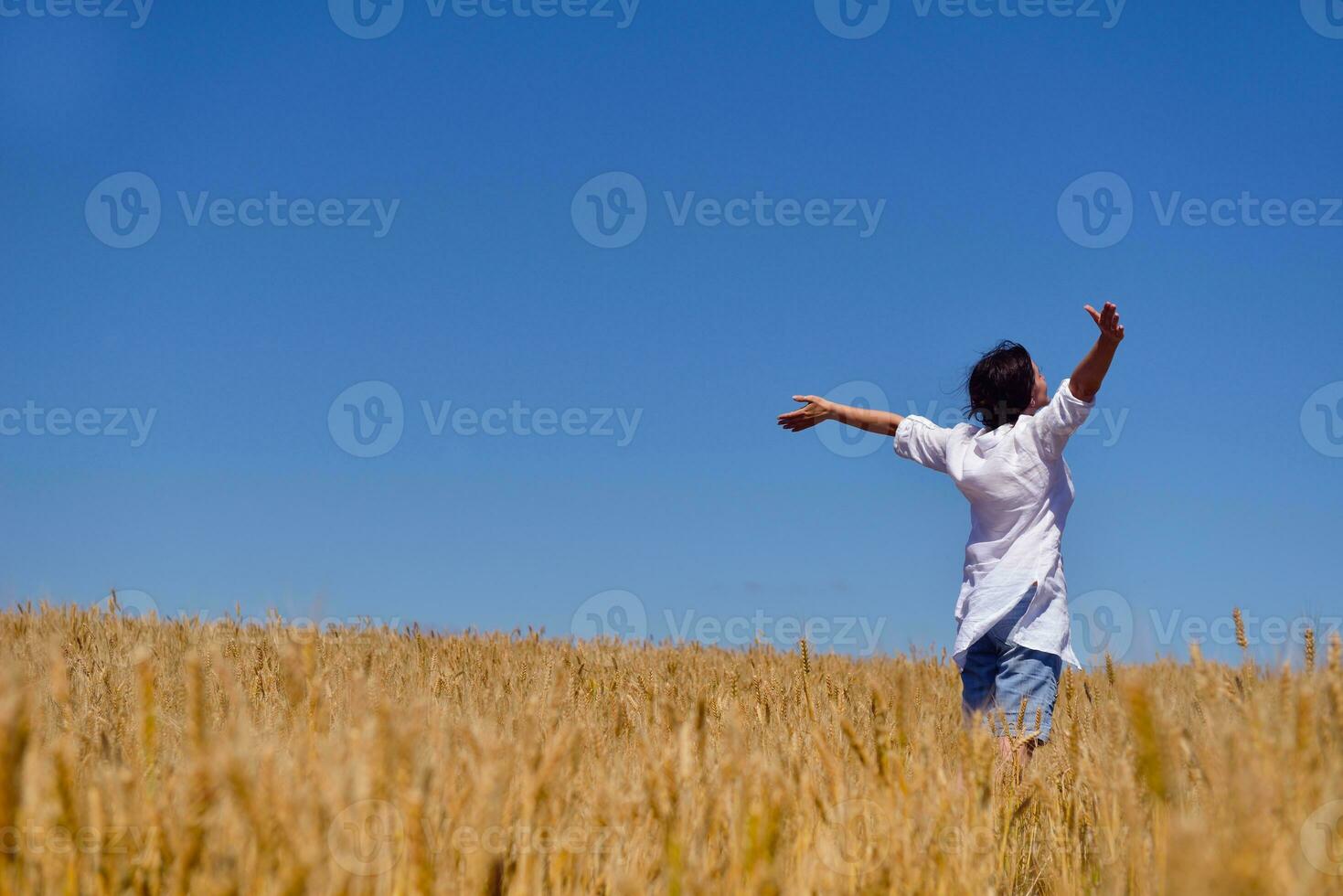 giovane donna nel campo di grano in estate foto