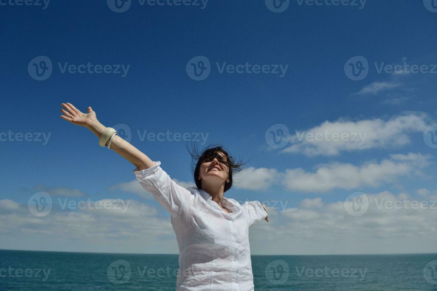 giovane donna con le braccia allargate al cielo foto