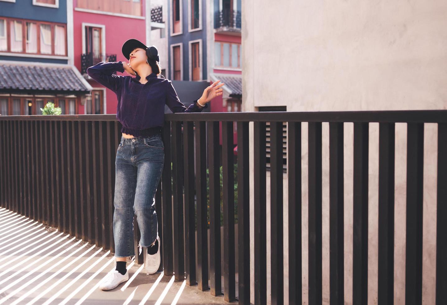 felice giovane donna asiatica che ascolta musica con le cuffie foto