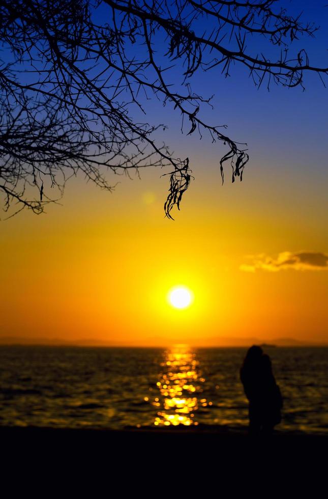 silhouette di persone e il mare al tramonto foto