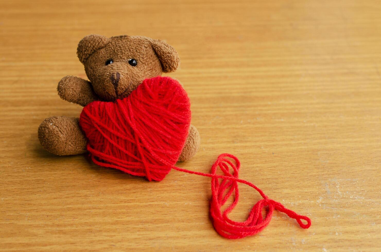 orsacchiotto con cuore rosso su sfondo di legno per il giorno di san valentino concept foto