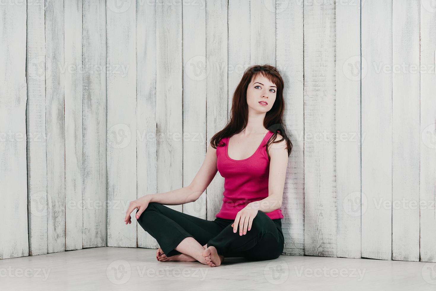 una bella ragazza in un top rosa, seduta sul pavimento in relax foto