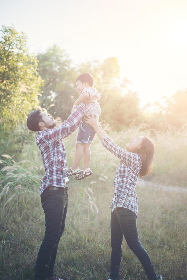 felice giovane famiglia che trascorre del tempo insieme all'esterno. concetto di amore familiare foto