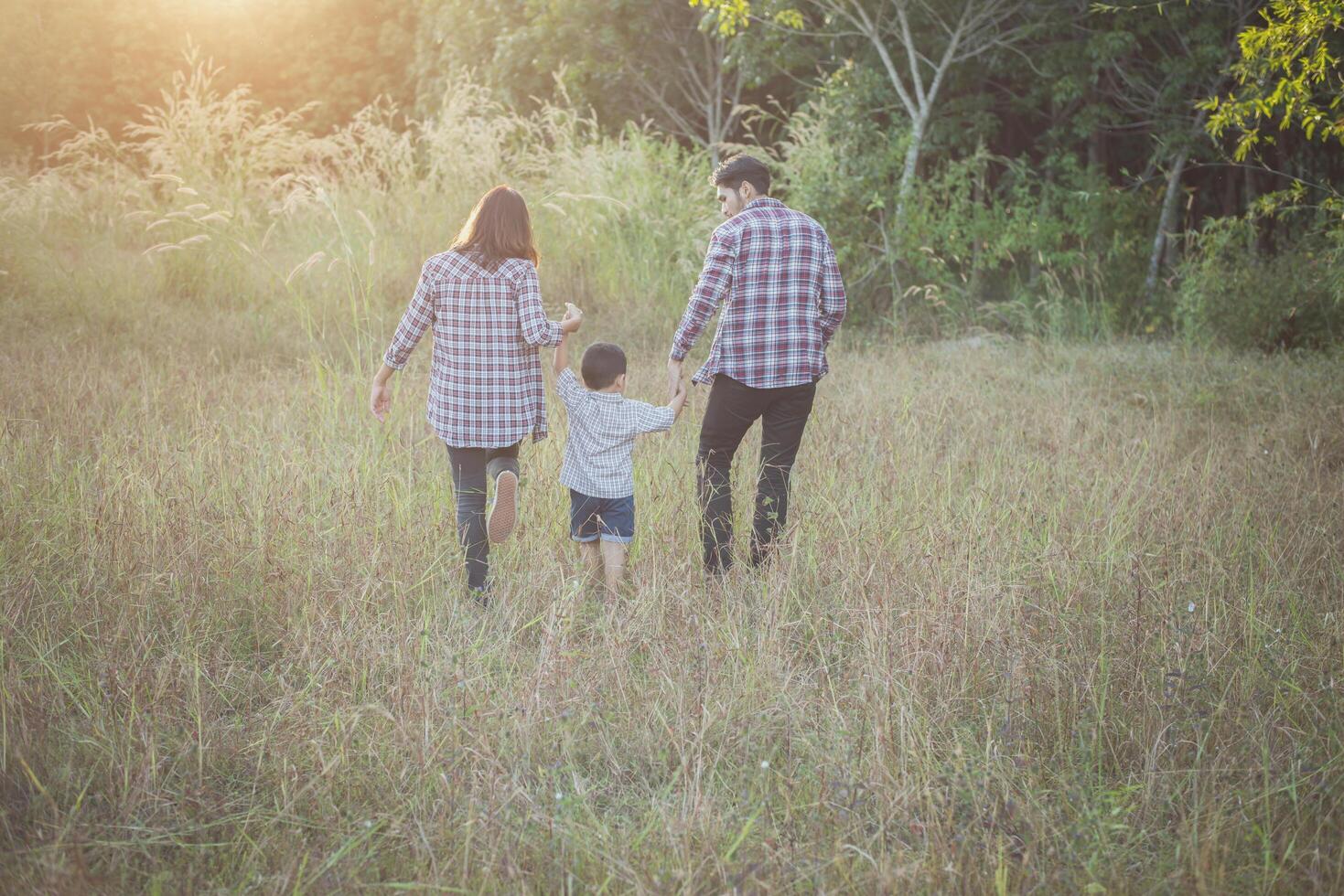 retro della giovane famiglia che trascorre del tempo insieme. famiglia all'aperto. foto