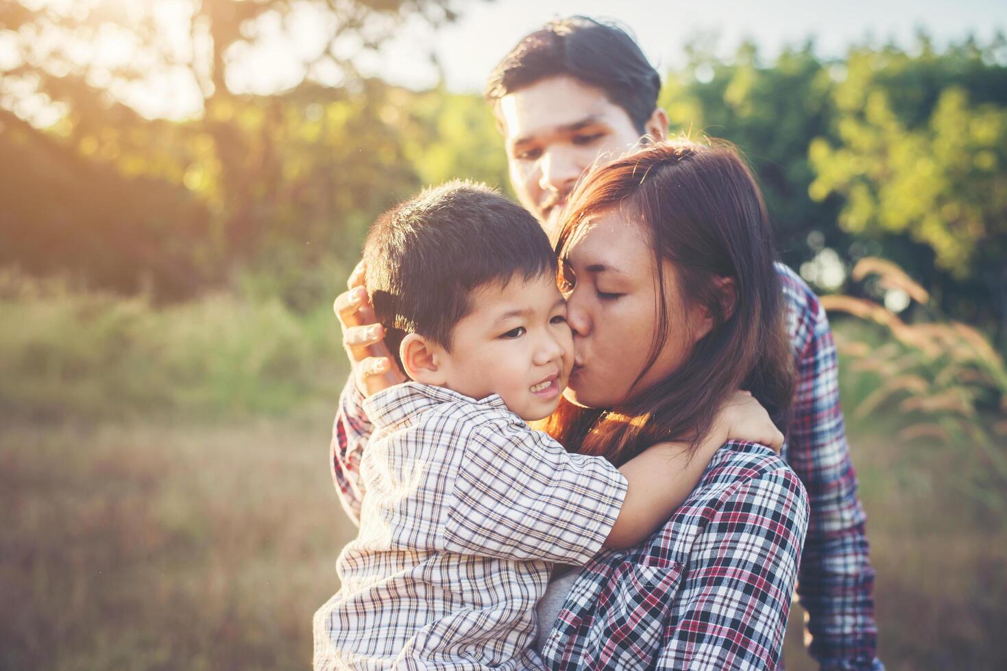 felice giovane famiglia che trascorre del tempo insieme all'esterno. concetto di amore familiare foto