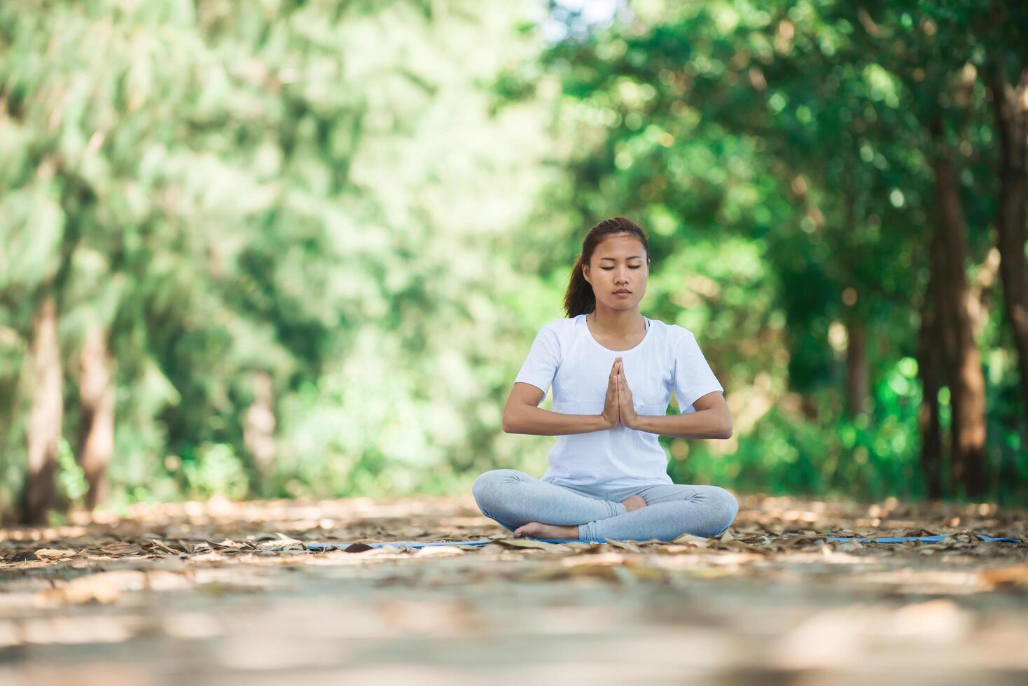 giovane donna asiatica che fa yoga al mattino al parco. foto