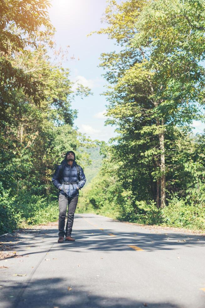 uomo escursionista che cammina sulla strada rurale. concetto di turismo di vacanza. foto