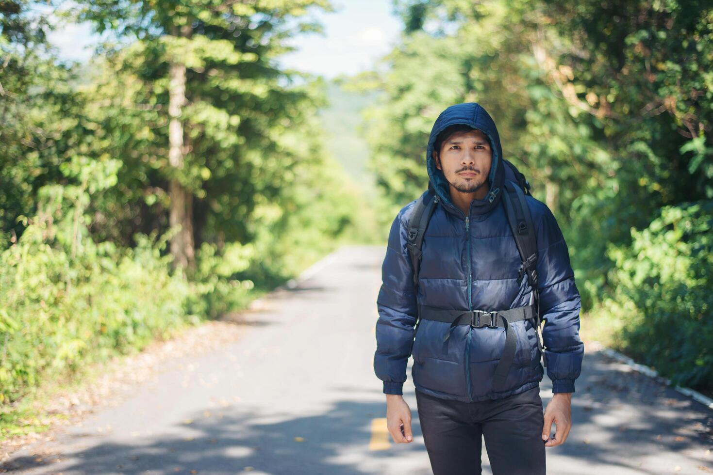 uomo escursionista che cammina sulla strada rurale. concetto di turismo di vacanza. foto