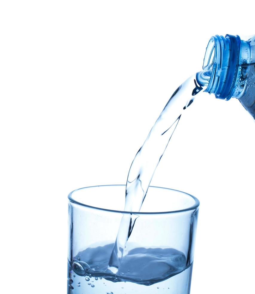 versando acqua dalla bottiglia in vetro foto