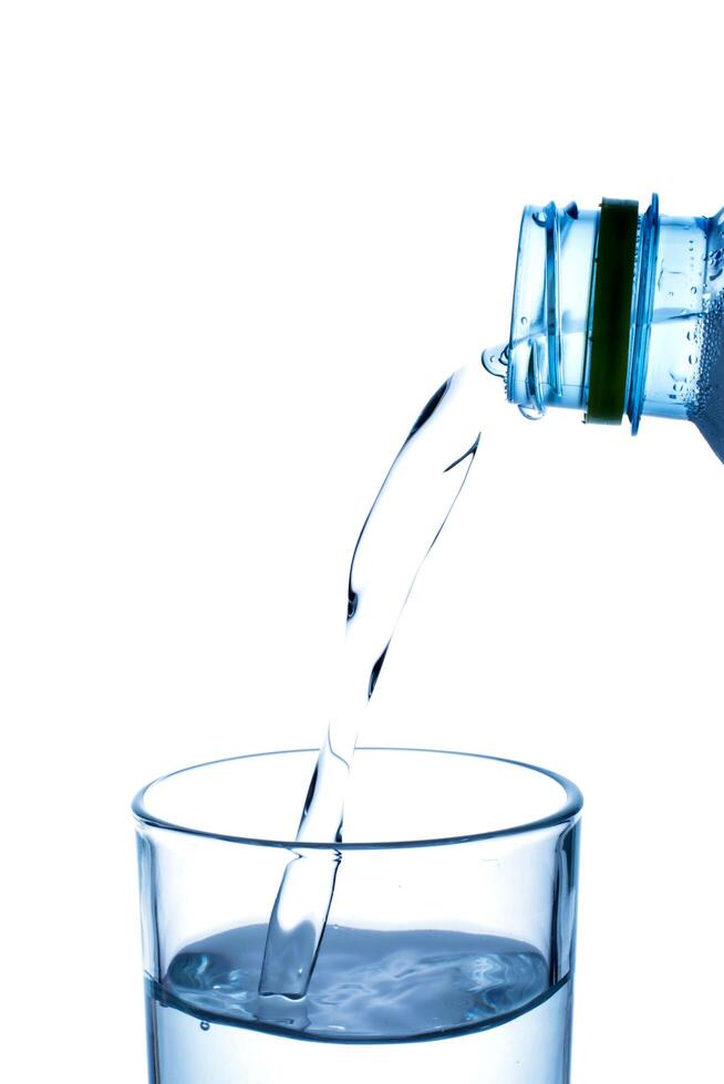 versando acqua dalla bottiglia in vetro foto