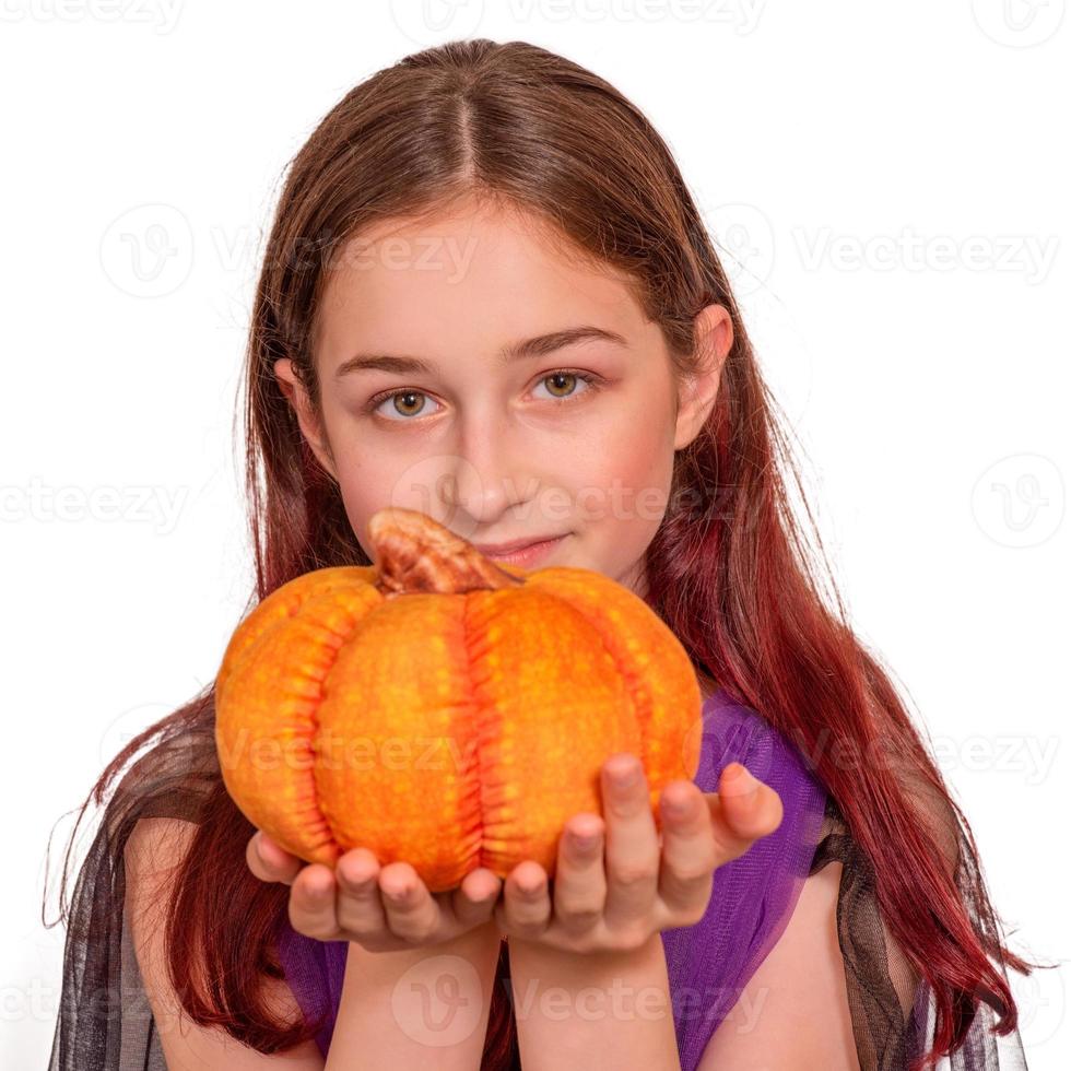 una giovane ragazza con una zucca in un costume di halloween isolare. foto