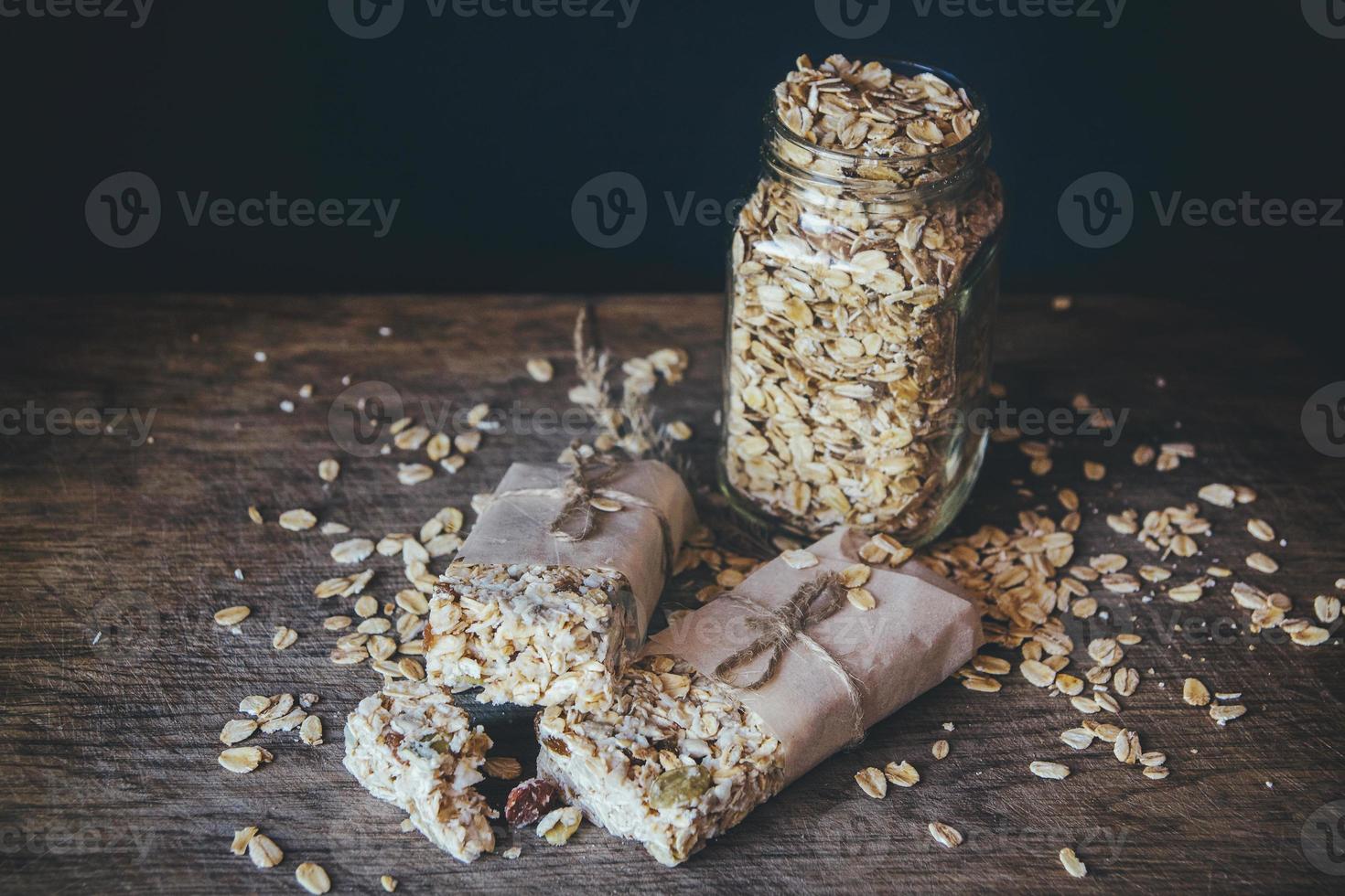 muesli fatti in casa con mix di noci in barattolo su sfondo di legno foto