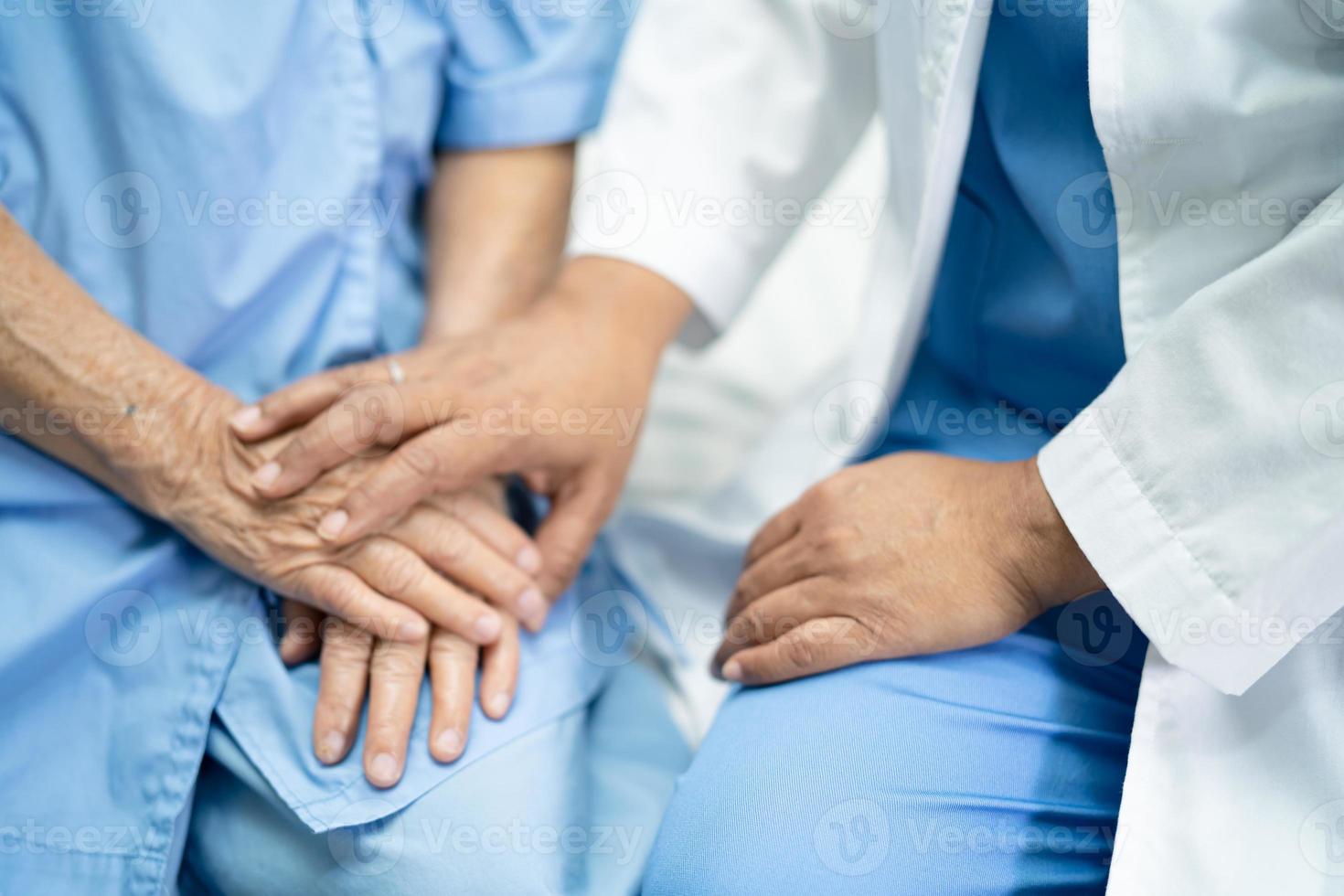 medico che tocca le mani signora anziana asiatica donna paziente con amore foto