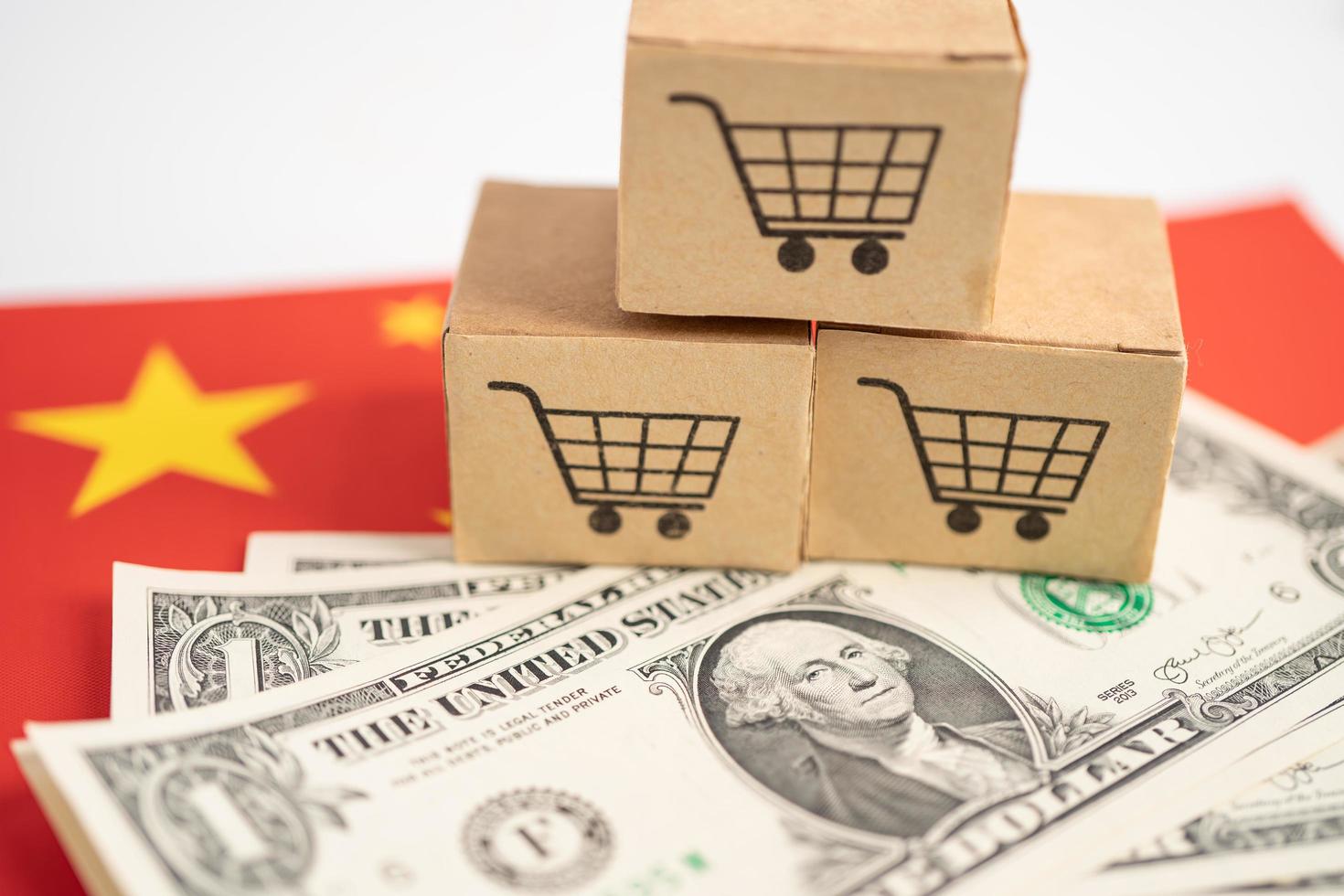 carrello della spesa con banconote in dollari americani sulla bandiera della Cina foto