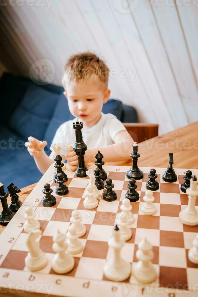 bambino giocando scacchi a casa a il tavolo foto