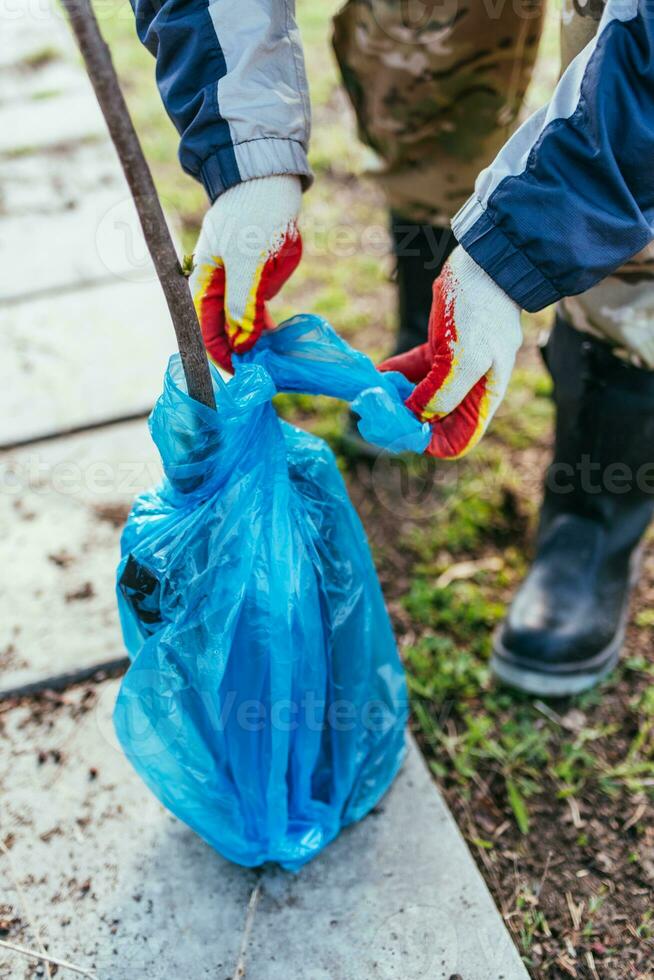 un' uomo impianti un' giovane frutta albero. il contadino disimballa un' nuovo piantina e mette esso nel il terra. il concetto di ambientale protezione e ecologia foto