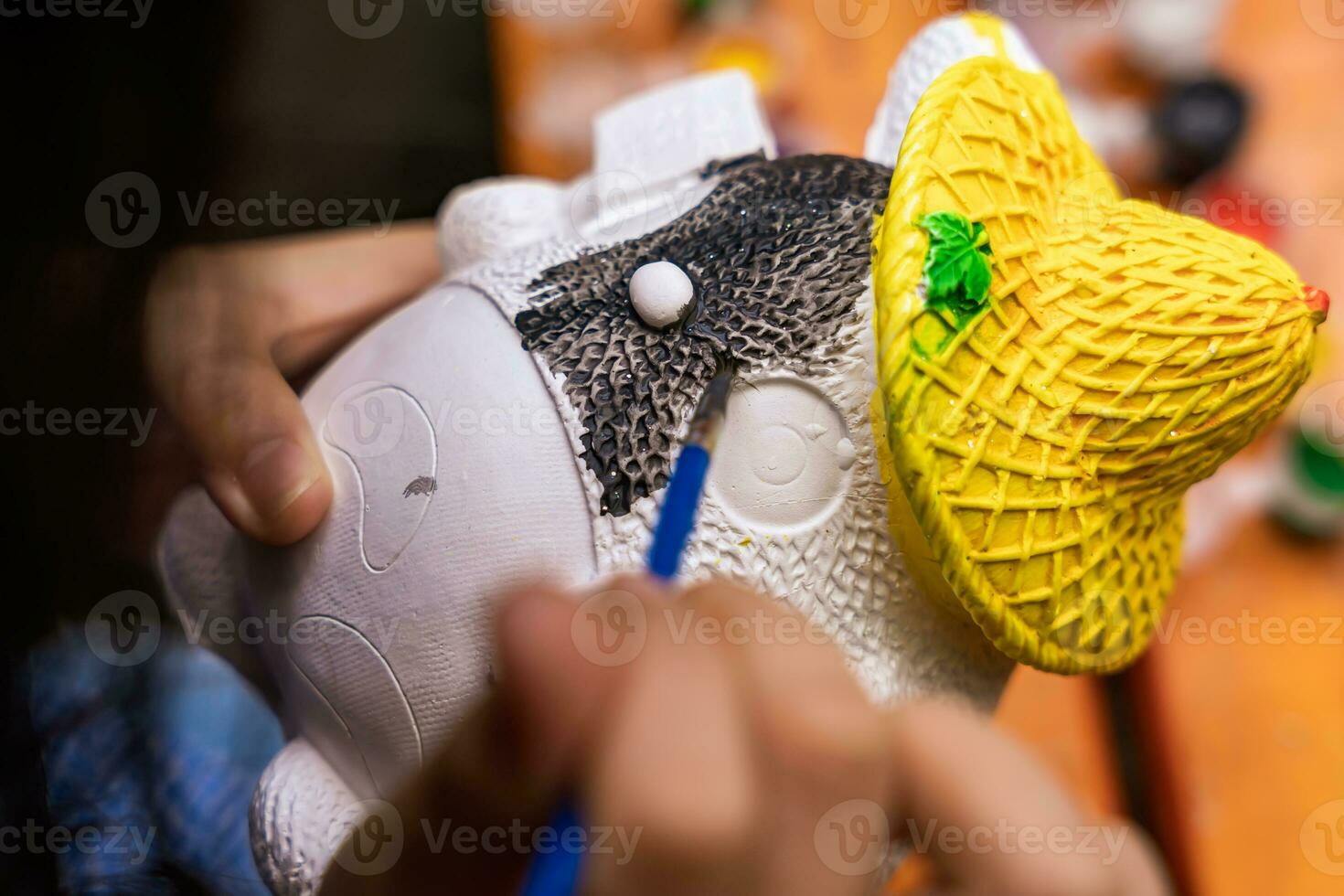 vicino su il capretto mano pittura colore su il gesso statua foto