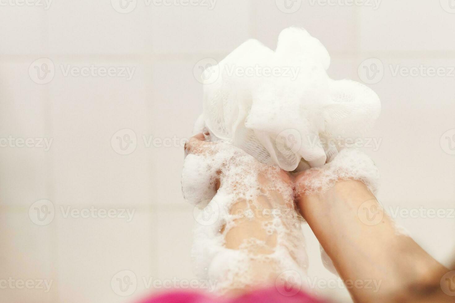 donna lavaggio mani con un' spugna nel il bagno. femmina lavaggio braccia con un' schiumoso spugna nel il bagno. corpo cura e pulito concetto foto