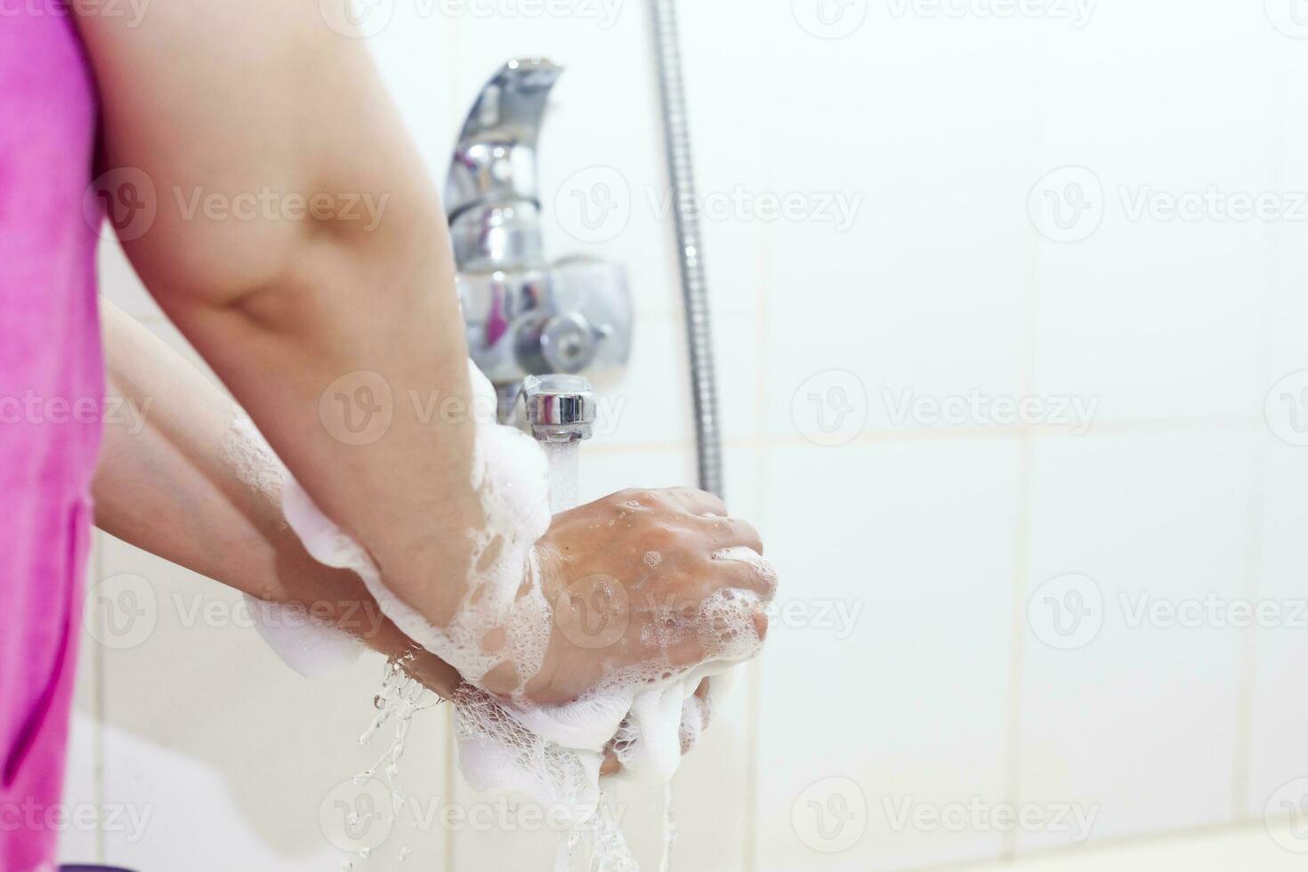 donna lavaggio mani con un' spugna nel il bagno. femmina lavaggio braccia con un' schiumoso spugna nel il bagno. corpo cura e pulito concetto foto