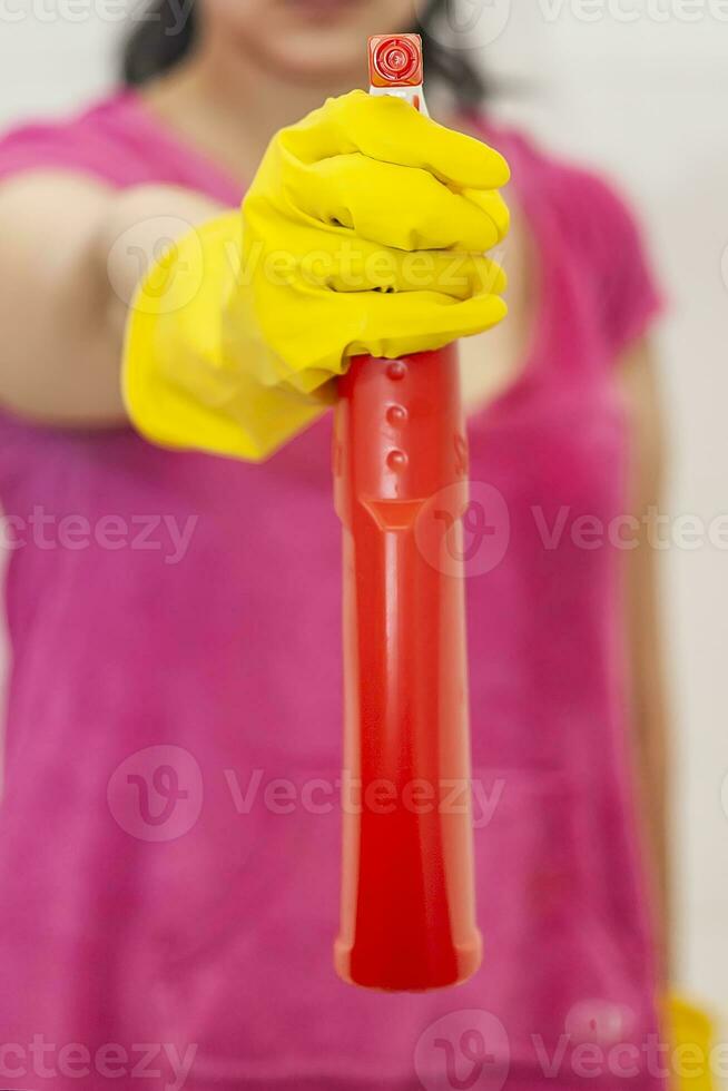donna con spray più pulito. casalinga Tenere rosso spray bottiglia a bagno. pulizia bagno foto