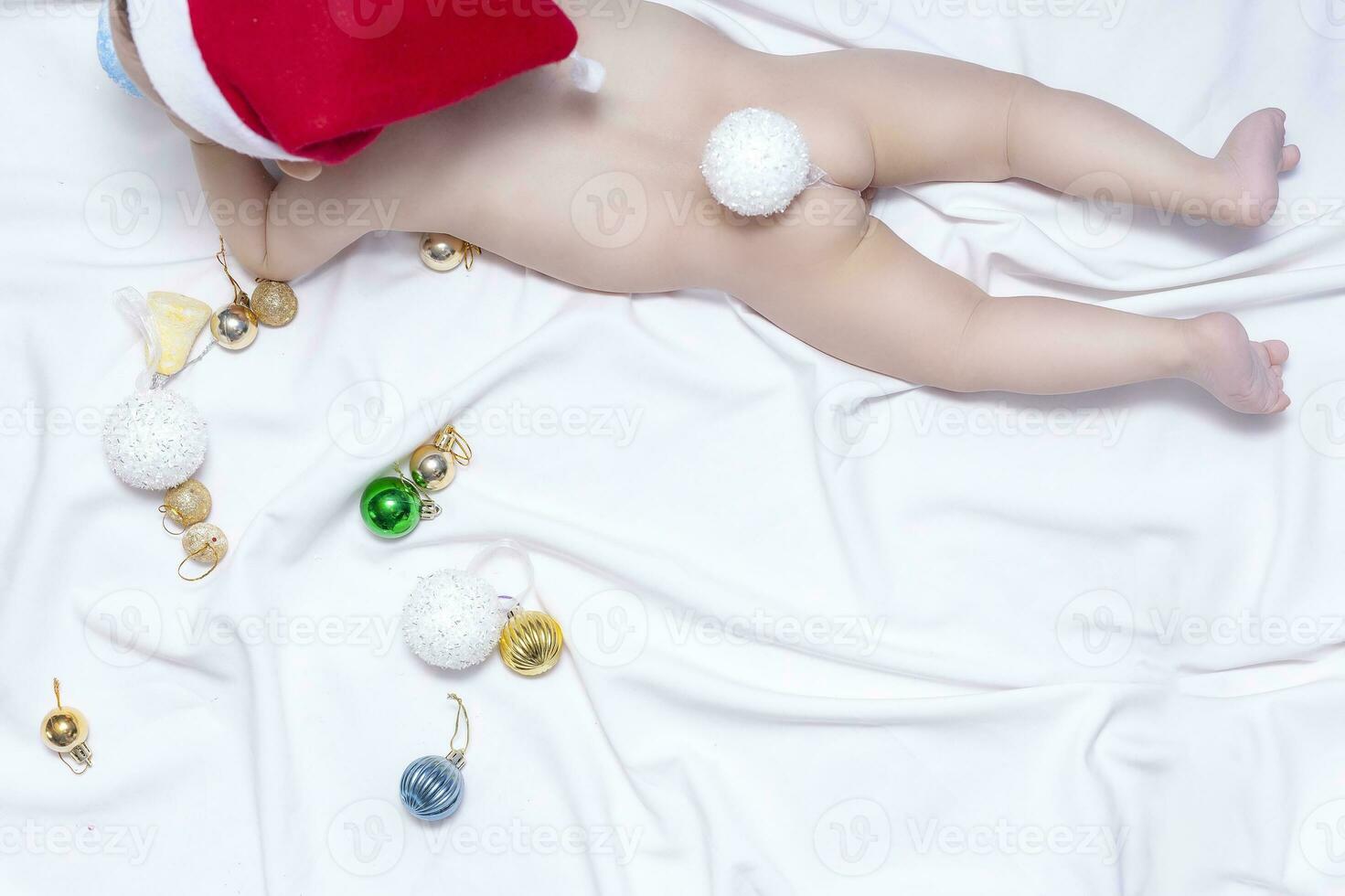 bambino ragazzo nel un' coniglietto costume. Natale coniglietto. 9 mesi bambino giocando con Natale palle e giocattoli foto