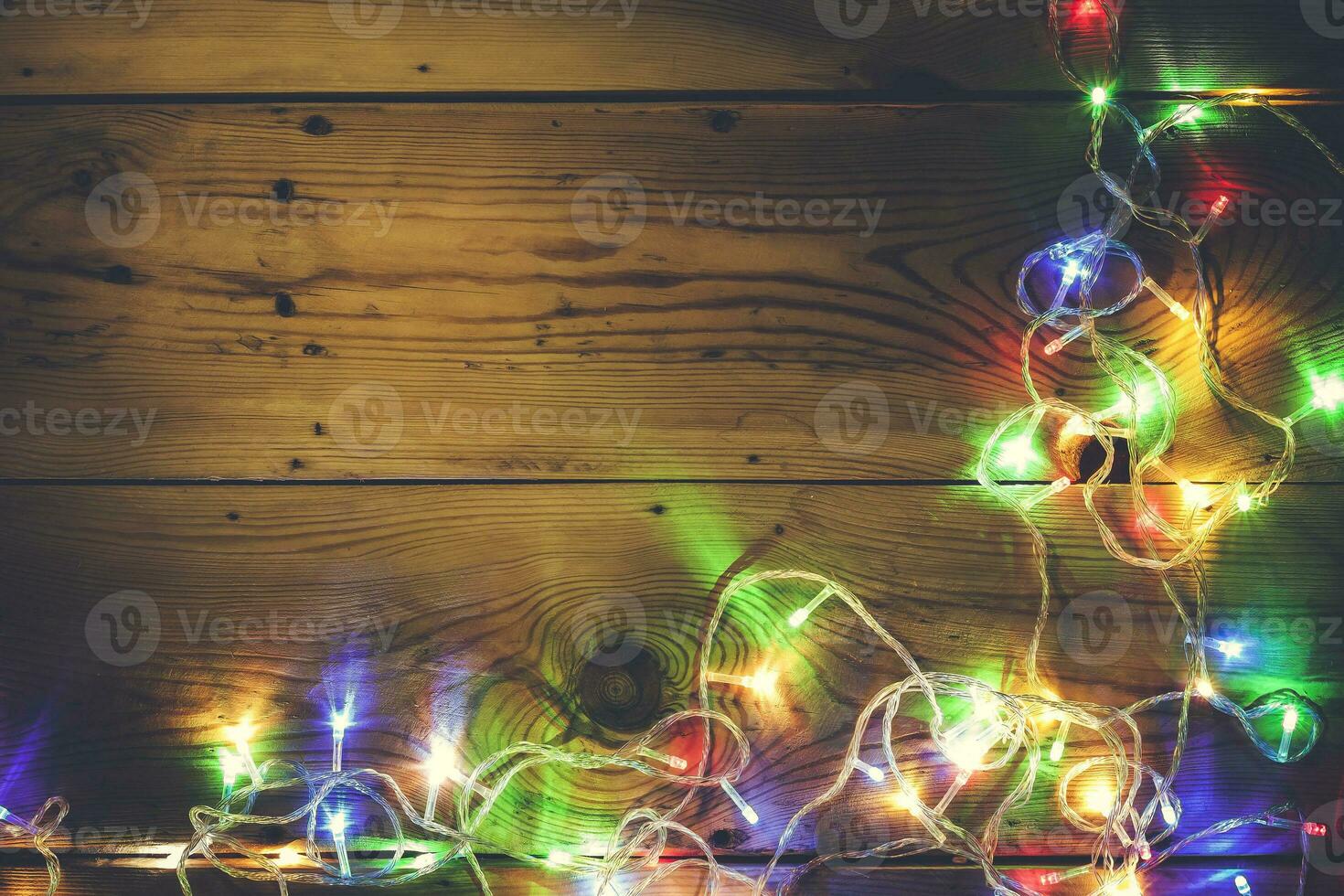 Natale decorativo luci. Natale ghirlanda luci su Di legno. colorato natale leggero bulbi su rustico Marrone tavola foto