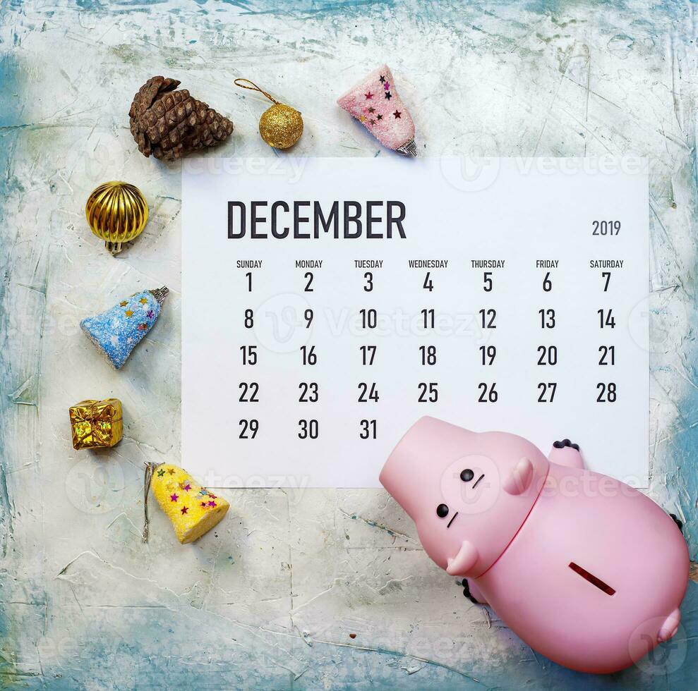 pianificazione il tuo Natale bilancio concetto. dicembre 2019 calendario con Natale giocattoli e porcellino banca foto