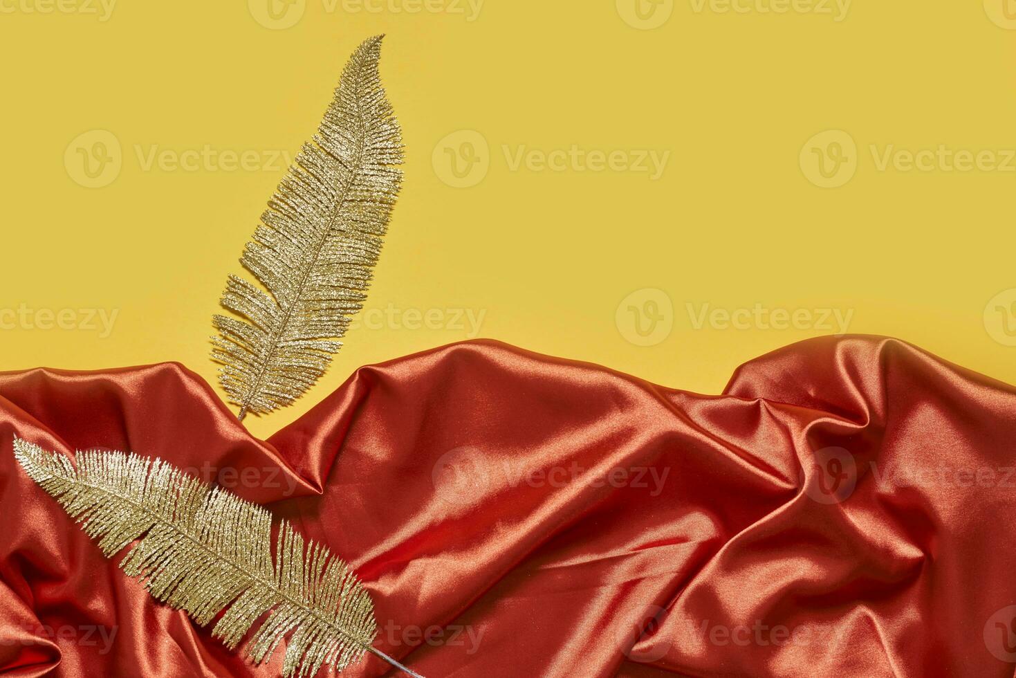 decorativo d'oro le foglie su rosso tessile fondale foto