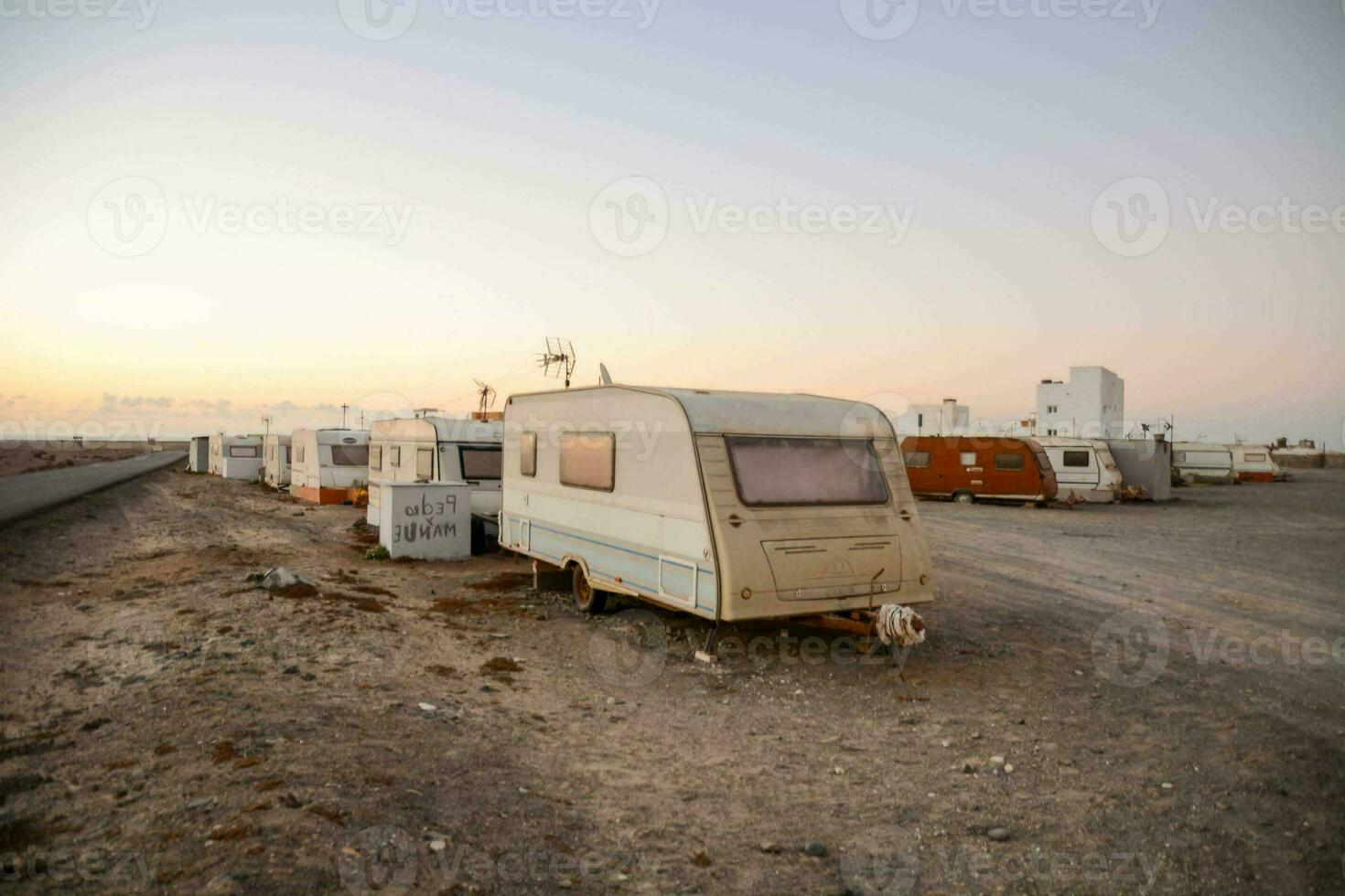 un' gruppo di vecchio camper furgoni parcheggiata nel un' campo foto