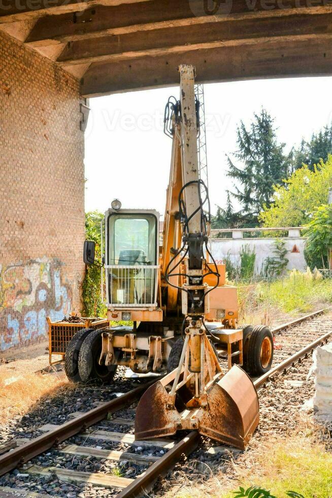 un' costruzione veicolo è parcheggiata sotto un' ponte foto