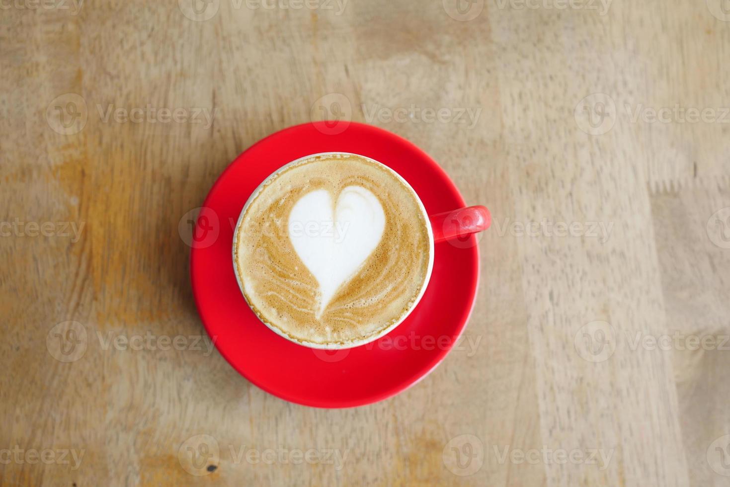 una tazza di caffè in ritardo con un design a forma di fiore in cima al bar foto