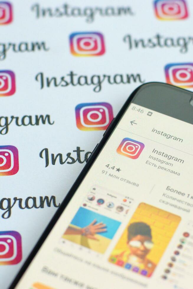 instagram App su Samsung smartphone schermo su bandiera con piccolo instagram loghi. instagram è americano foto e condivisione video sociale networking servizio di Facebook inc