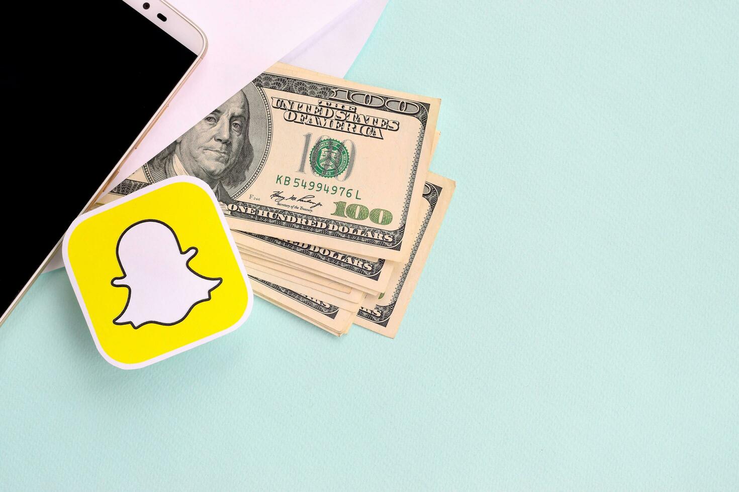 Snapchat carta logo bugie con Busta pieno di dollaro fatture e smartphone foto