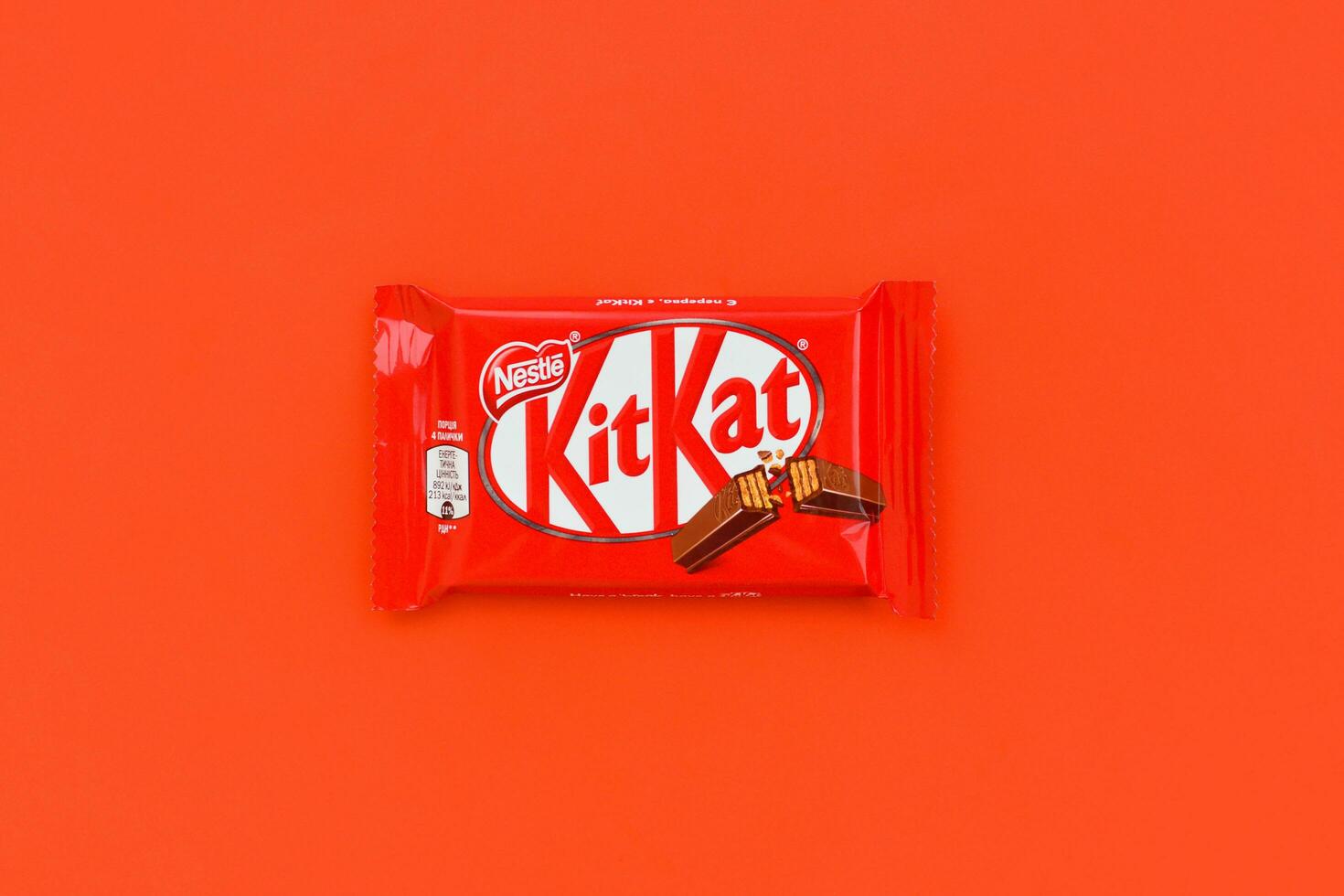 kit Kat cioccolato bar nel rosso involucro bugie su rosso sfondo. kit Kat creato di Rowntree di York nel unito regno e è adesso prodotta globalmente di annidarsi foto