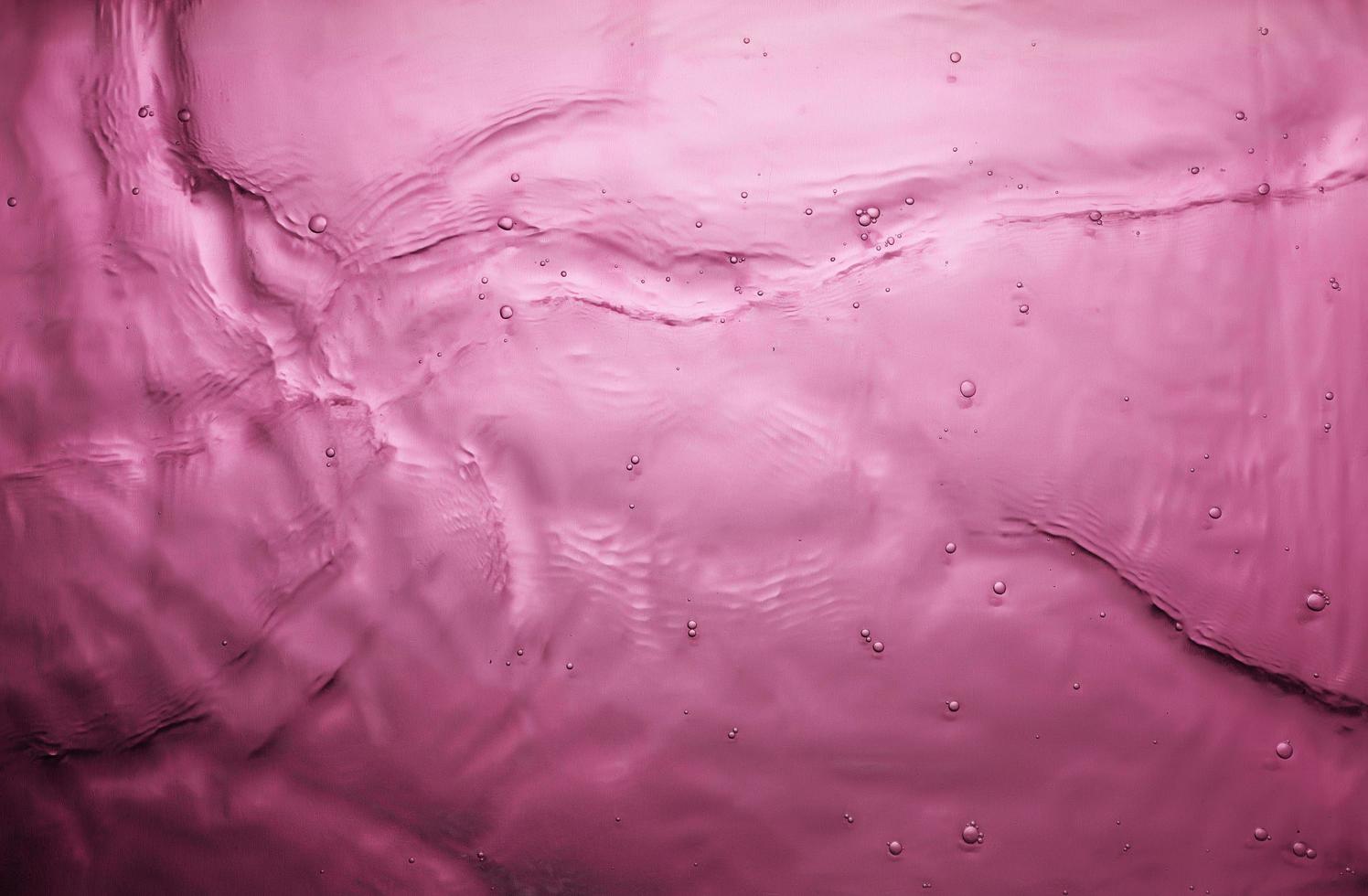 trama di spruzzi d'acqua su sfondo rosa foto