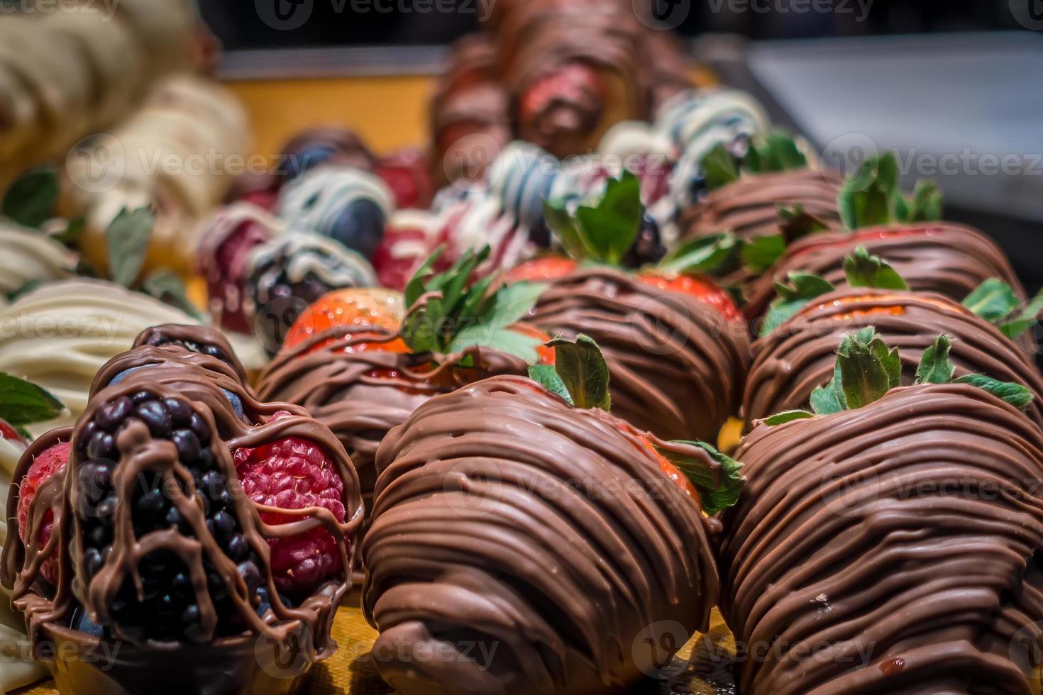 fragole ricoperte di cioccolato in esposizione in negozio foto