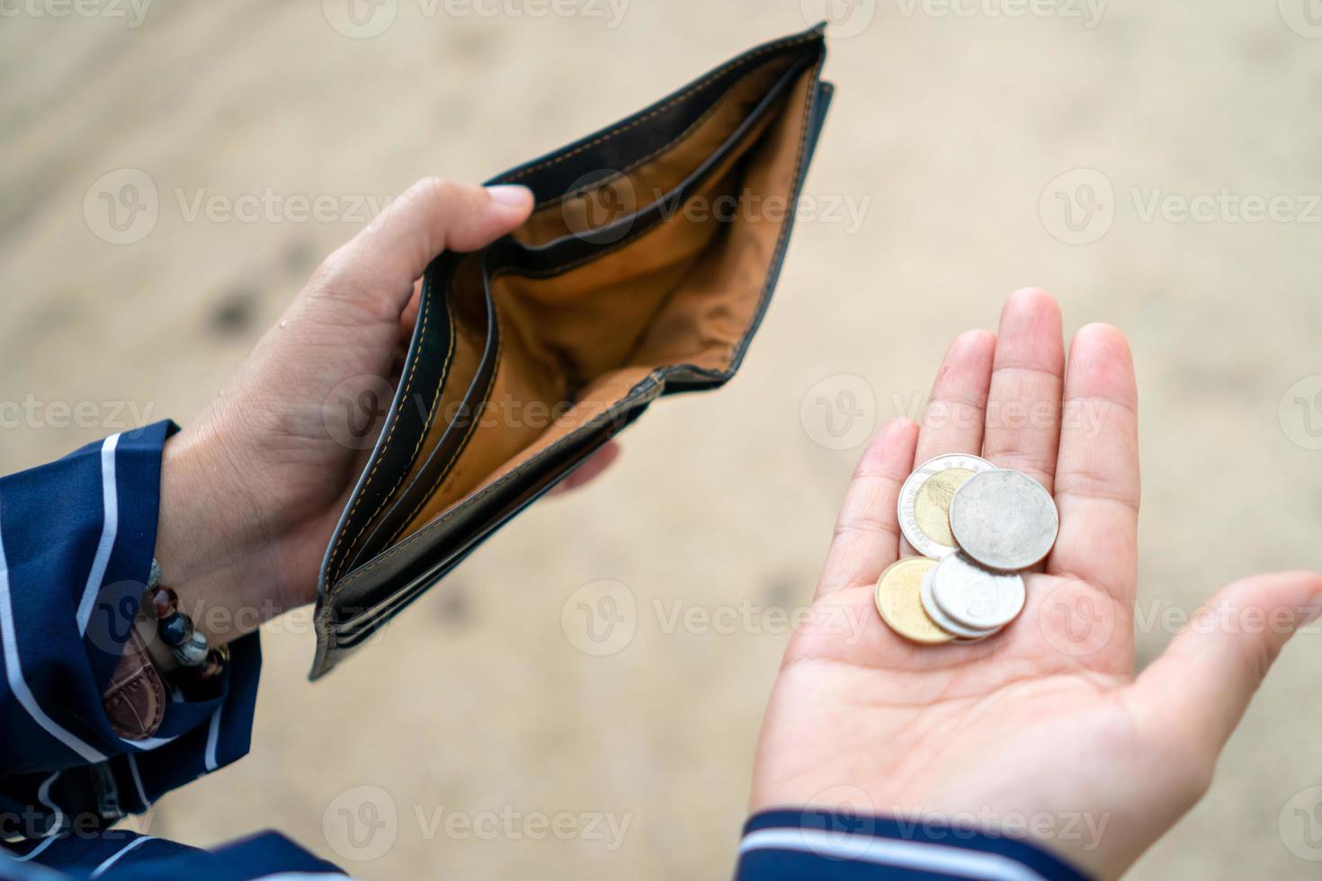 la donna tiene in mano una borsa vuota e monete. foto