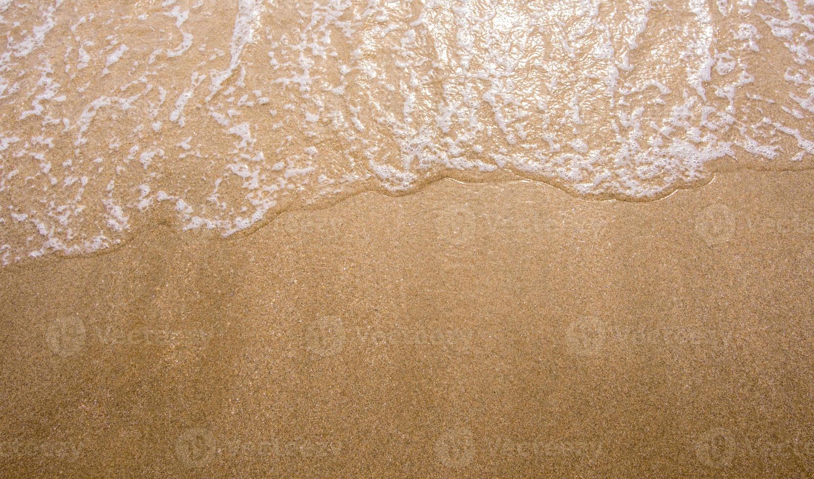 bolla bianca dell'onda del mare sulla spiaggia foto