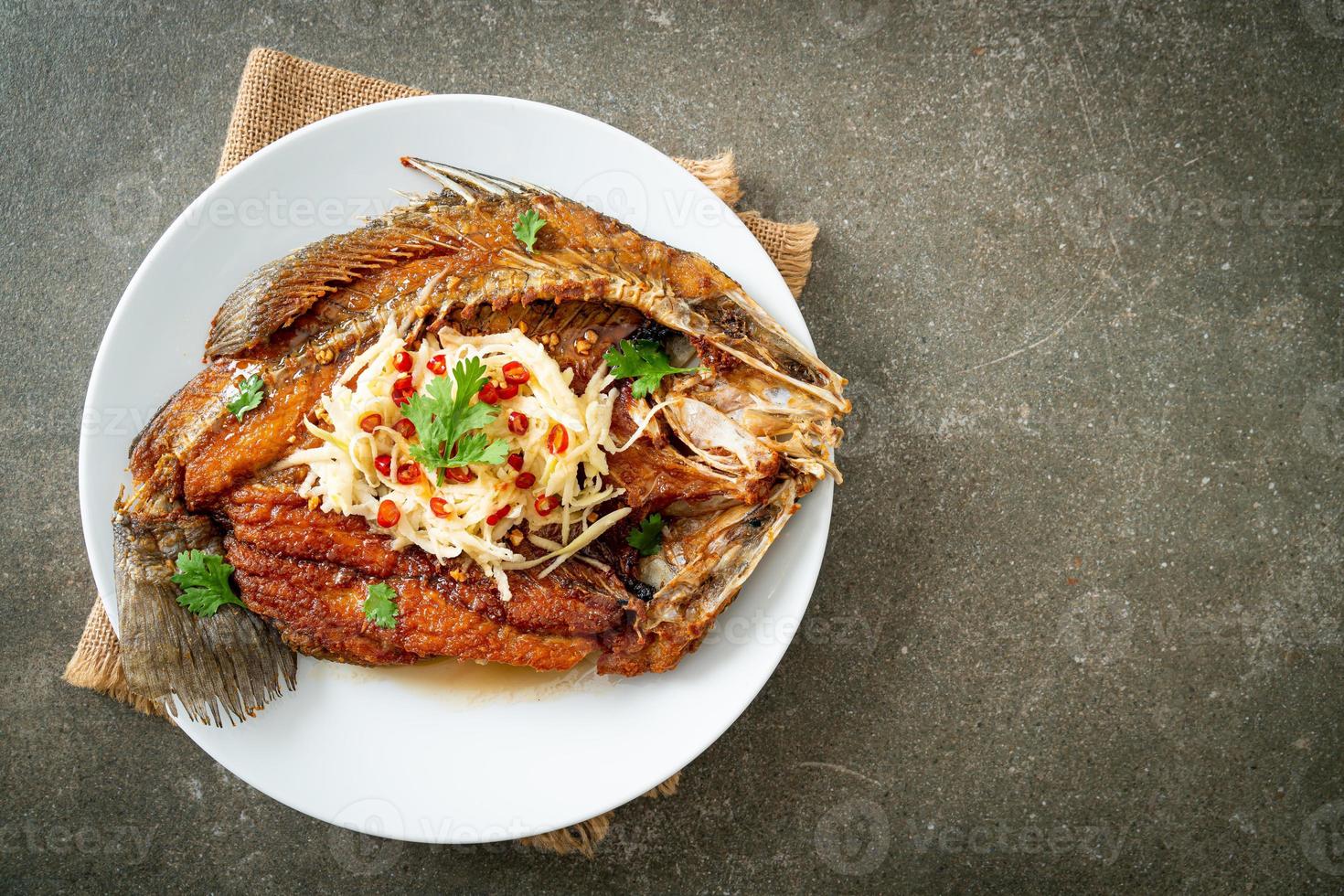 branzino fritto con salsa di pesce e insalata piccante foto