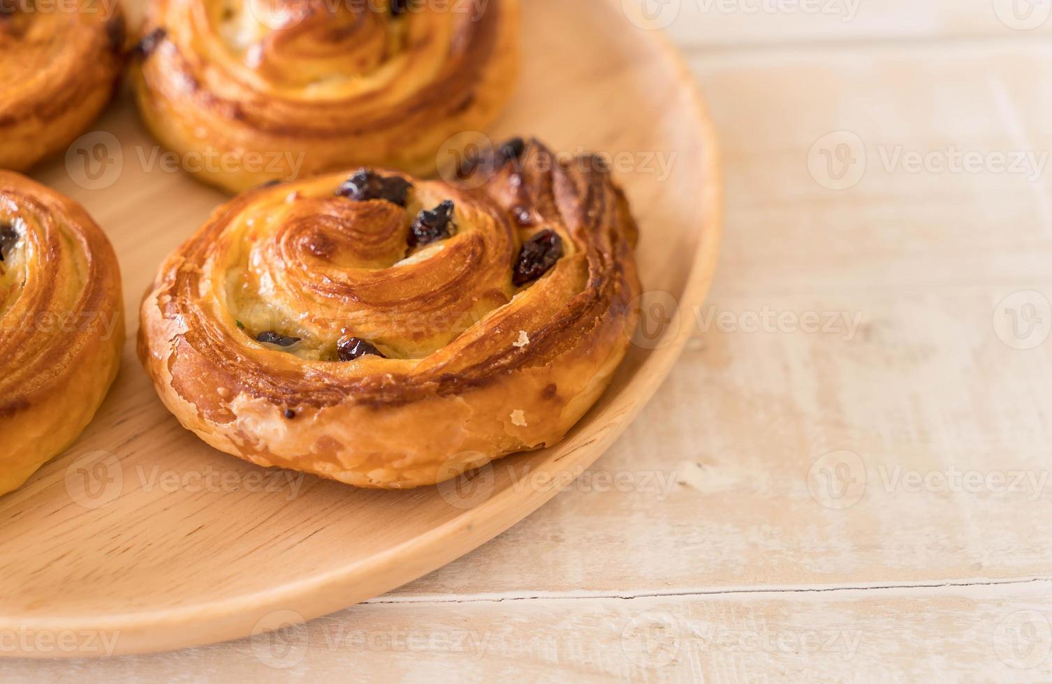 rotolo di uvetta alla cannella su piatto di legno foto