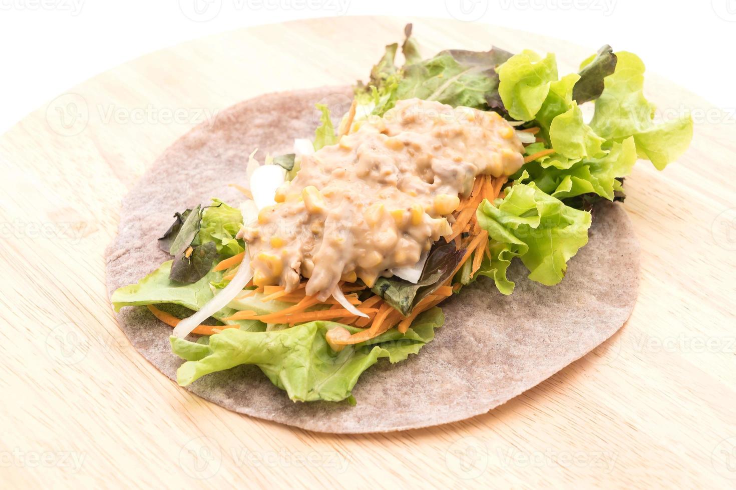 avvolgere il rotolo di insalata con tonno e insalata di mais su piatto di legno foto