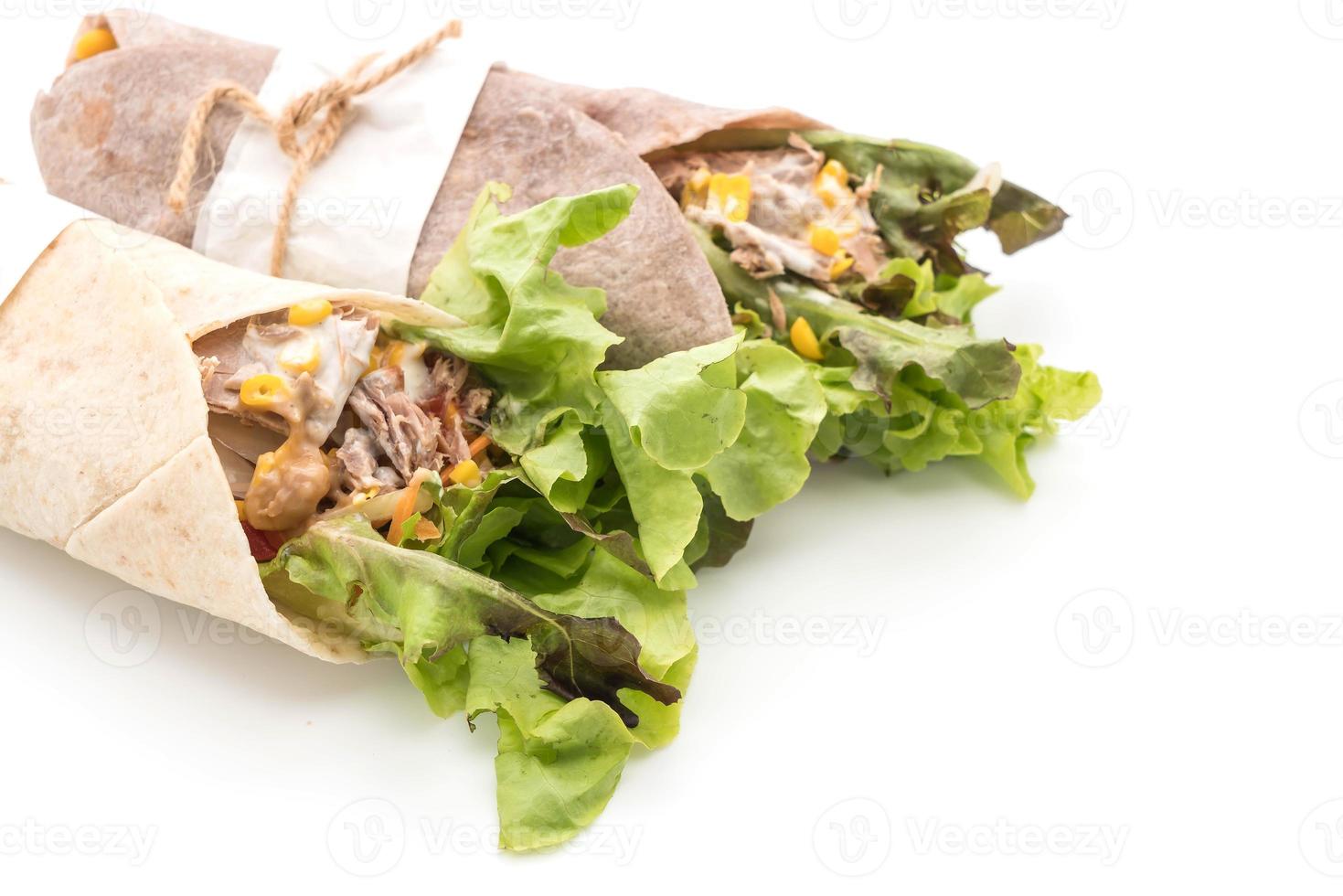 avvolgere il rotolo di insalata con tonno e insalata di mais su sfondo bianco foto