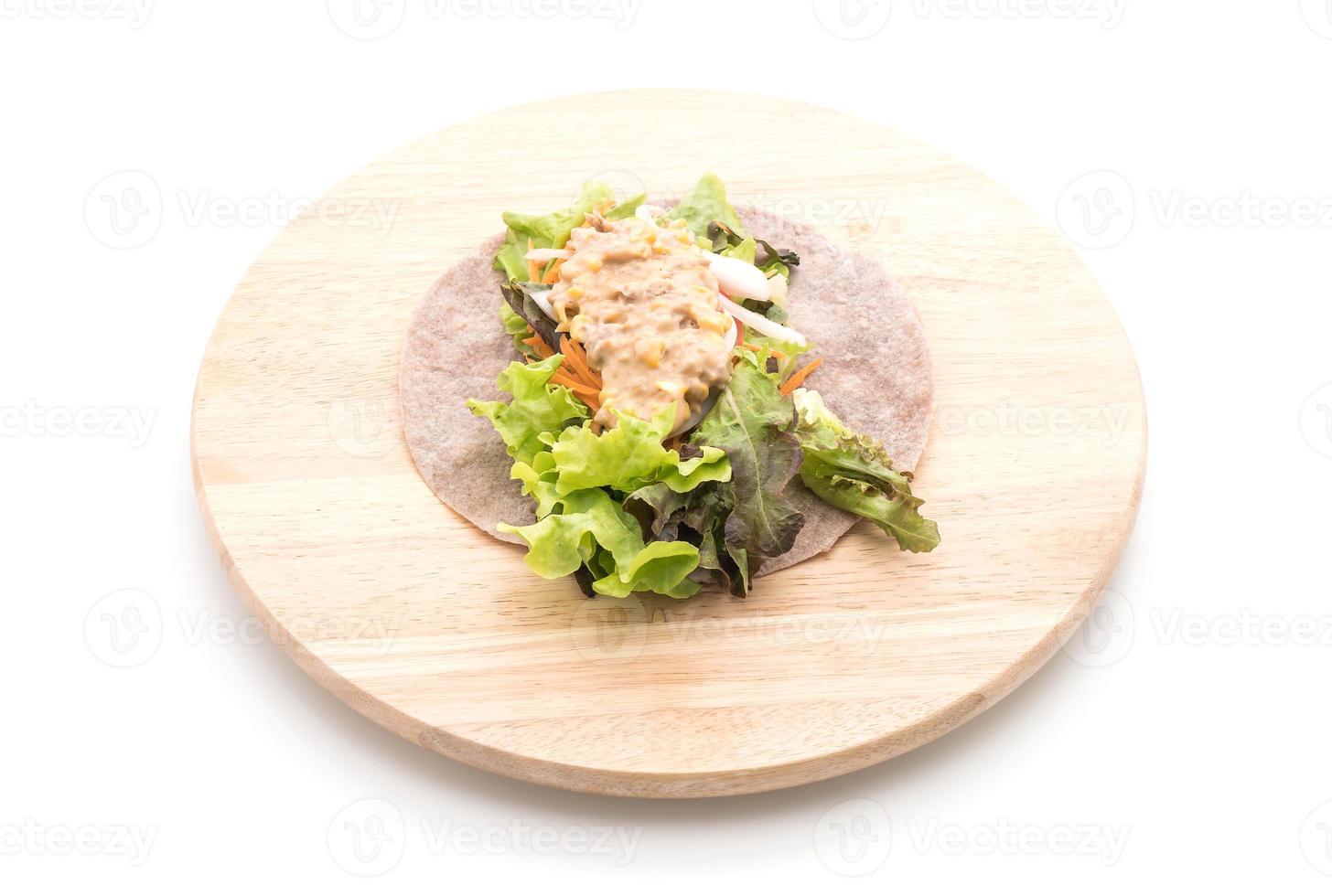avvolgere il rotolo di insalata con tonno e insalata di mais su sfondo bianco foto