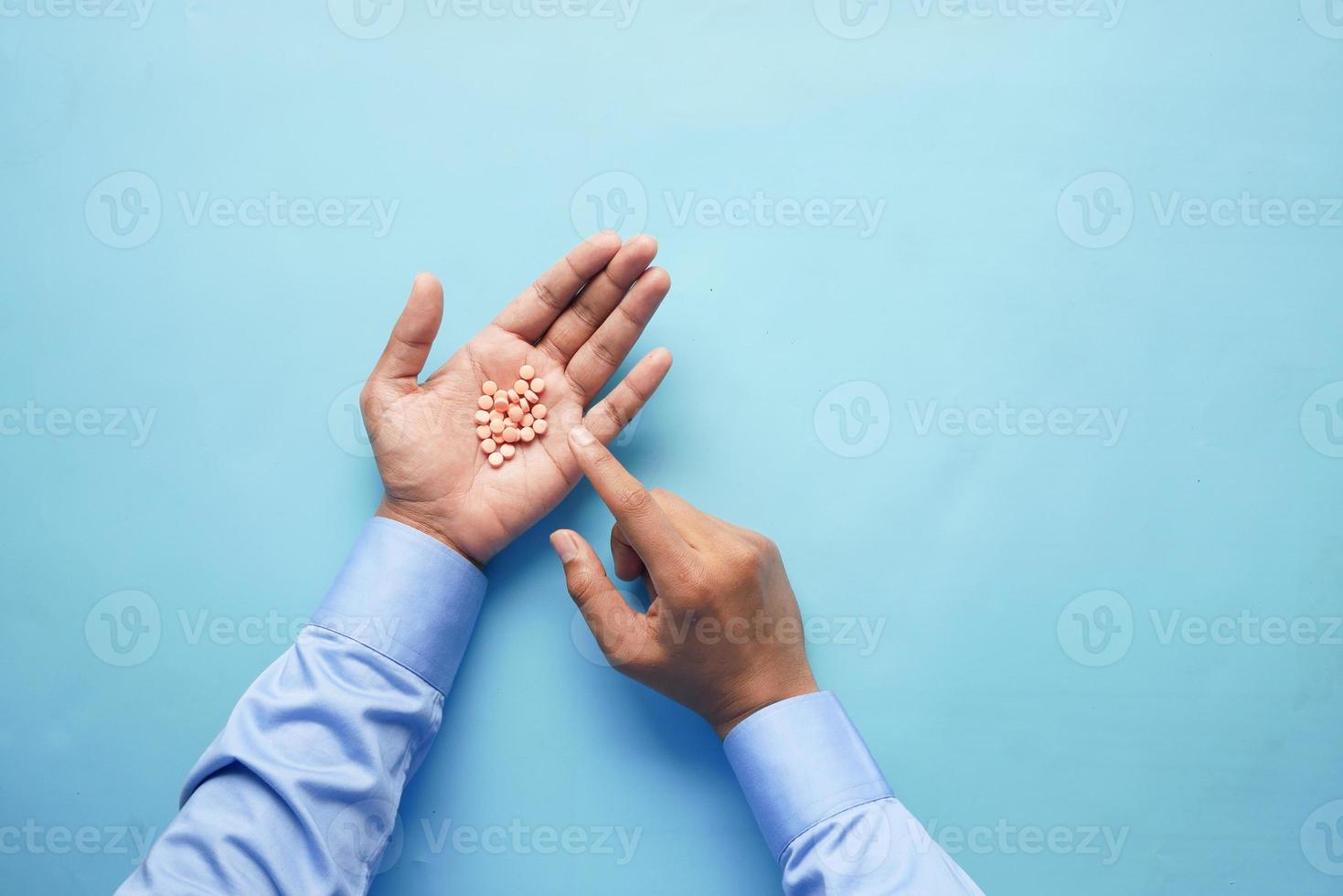 mano d'uomo con la medicina fuoriuscito dal contenitore della pillola foto