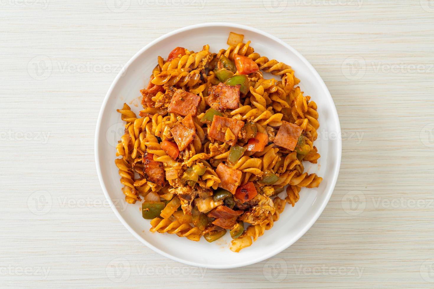 fusilli saltati in padella con prosciutto e salsa di pomodoro foto