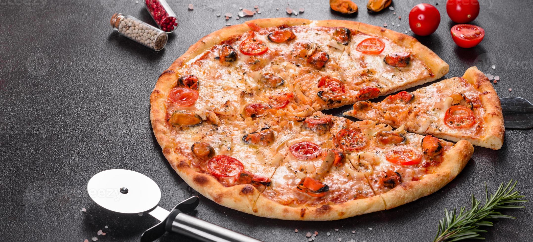 gustosa pizza a fette con frutti di mare e pomodoro su fondo di cemento foto