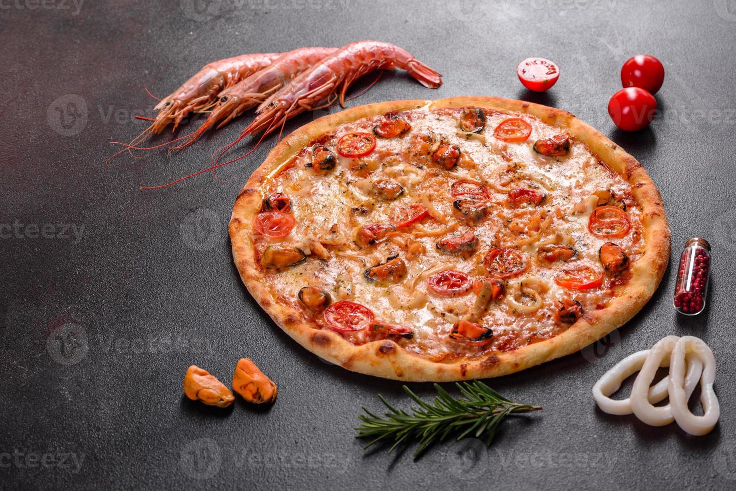 gustosa pizza a fette con frutti di mare e pomodoro su fondo di cemento foto