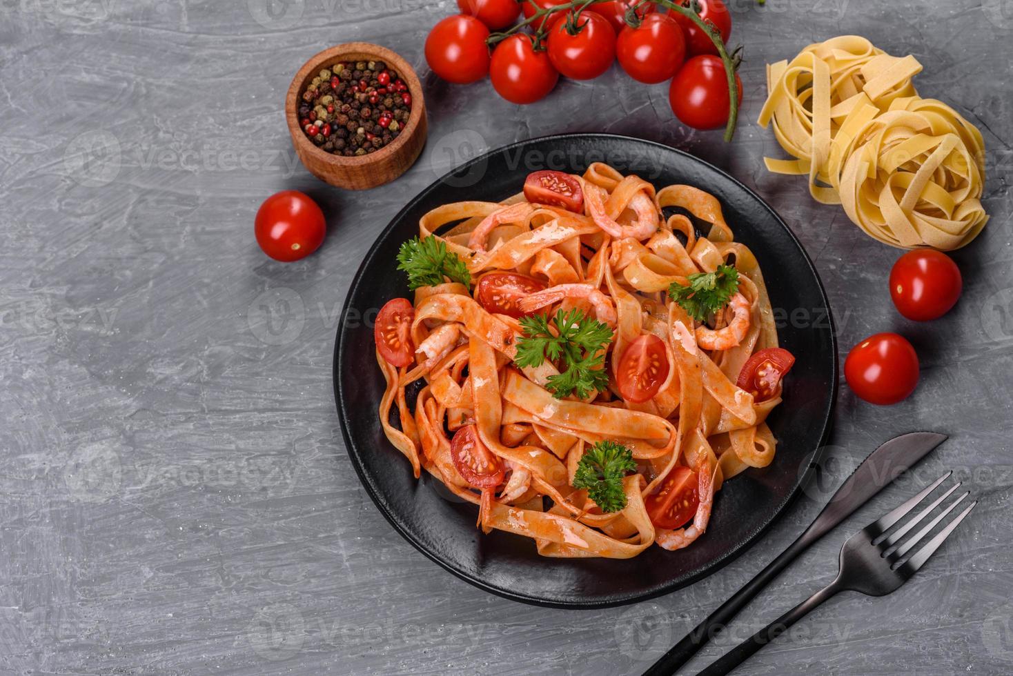 fettuccine con gamberi, pomodorini, salsa, spezie ed erbe aromatiche foto